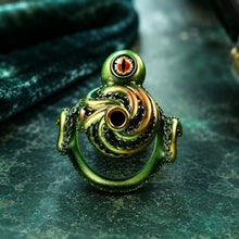 Load image into Gallery viewer, Front view of the Abyssal Eye Alloy Chastity Cage with a red eye and green-and-bronze tentacle design
